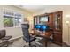 Comfortable home office with wooden desk, built-in storage, and natural light at 1033 Via Dell Bacio Dr, Henderson, NV 89052