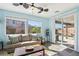 Bright living room features a ceiling fan, plush sofa, and sliding glass door to the backyard at 1033 Via Dell Bacio Dr, Henderson, NV 89052