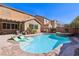 Inviting backyard pool with a built-in spa, tanning ledge, and poolside lounge chairs at 1033 Via Dell Bacio Dr, Henderson, NV 89052