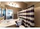 Bathroom with a single sink vanity, toilet, and a shower/tub combination with a striped curtain at 1056 Sweeping Ivy Ct, Las Vegas, NV 89183