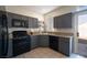 Charming kitchen featuring gray cabinets, stainless steel appliances, and granite countertops, connecting to an outdoor patio at 1056 Sweeping Ivy Ct, Las Vegas, NV 89183