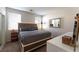 Bright main bedroom featuring a large bed, stylish furniture, and natural light from two windows at 1056 Sweeping Ivy Ct, Las Vegas, NV 89183