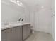 This bathroom features a dual sink vanity, gray cabinetry, and tile flooring at 1103 Tektite Ave, Henderson, NV 89011