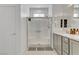 This bathroom showcases a glass shower, vanity with gray cabinetry, and white walls at 1103 Tektite Ave, Henderson, NV 89011