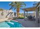 Private backyard oasis featuring a pool, lounge chairs, covered patio, and lush landscaping at 1110 Legato Dr, Las Vegas, NV 89123