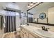 Bathroom with double sinks, large mirror, tile floors and shower-tub combination with gray curtain at 1110 Legato Dr, Las Vegas, NV 89123