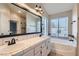 Bathroom featuring double sinks, soaking tub, and natural light from a large window at 1110 Legato Dr, Las Vegas, NV 89123