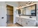 Bathroom featuring dual sinks, a large mirror, and a walk-in closet offering ample storage at 1110 Legato Dr, Las Vegas, NV 89123