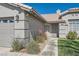 Close up of home entry with gray tone exterior, shade shutters, rock landscaping and bright green lawn at 1110 Legato Dr, Las Vegas, NV 89123