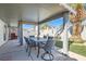 Covered patio with dining table, overlooking a well-manicured backyard with artificial grass at 1110 Legato Dr, Las Vegas, NV 89123