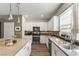 Modern kitchen featuring stainless steel appliances, white cabinetry, island seating, and a decorative backsplash at 11256 Rainbow Peak Ave # 207, Las Vegas, NV 89135