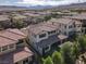 Wide aerial view of the property showcasing community's layout, neighboring homes and trees at 12054 Portamento Ct, Las Vegas, NV 89138