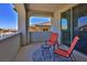 Outdoor balcony features chairs, table and sliding glass door with a view at 12054 Portamento Ct, Las Vegas, NV 89138