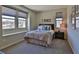 Bedroom featuring cozy carpet, natural lighting from two windows, and neutral decor at 12054 Portamento Ct, Las Vegas, NV 89138