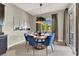 Bright dining area with a round table, blue chairs, and natural light at 12054 Portamento Ct, Las Vegas, NV 89138