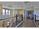 Upstairs hallway with dark wood floors, modern metal railings, and a large portrait at 12054 Portamento Ct, Las Vegas, NV 89138