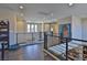 Upstairs hallway featuring metal railing, view of the main floor, and a large portrait at 12054 Portamento Ct, Las Vegas, NV 89138