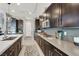 Contemporary kitchen with dark wood cabinetry, stainless steel appliances, and modern backsplash at 12054 Portamento Ct, Las Vegas, NV 89138