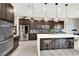 Sleek kitchen with stainless steel appliances, a large island, and modern pendant lights at 12054 Portamento Ct, Las Vegas, NV 89138