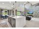 Bright open-concept living space featuring a large kitchen island and a soaring accent wall at 12054 Portamento Ct, Las Vegas, NV 89138