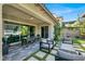 Covered patio area with table, chairs, and sofa seating with access to the lawn at 12054 Portamento Ct, Las Vegas, NV 89138