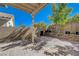 This backyard with a retaining wall and a shady covered area at 1421 Hometown Ave, Henderson, NV 89074