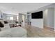 Open concept living space with large TV and neutral paint complemented by wood-look tile flooring at 1421 Hometown Ave, Henderson, NV 89074