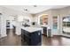 Modern kitchen with stainless appliances, white cabinets, island with dark base, and backyard view at 1426 Clipperton Ave, Henderson, NV 89074