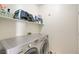 Well-organized laundry room features a washer, dryer, and storage shelves at 1426 Clipperton Ave, Henderson, NV 89074