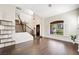 Bright living room with a tall ceiling, plantation shutters, dark wood flooring, and staircase at 1426 Clipperton Ave, Henderson, NV 89074