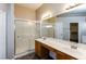 Bathroom featuring double sinks, a large mirror, and a walk-in shower at 144 La Mirada Dr, Henderson, NV 89015