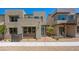 Modern townhome with stucco exterior, blue door, minimalist landscaping, and second story balcony at 1479 Melodic Lark Dr, Las Vegas, NV 89138