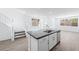 Kitchen with island and stainless steel sink overlooks living area and stairway at 1479 Melodic Lark Dr, Las Vegas, NV 89138