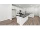 Modern kitchen with white cabinets, an island with seating, and wood-look tile floors at 1479 Melodic Lark Dr, Las Vegas, NV 89138