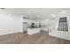 Open-concept space with wood-look tile, white walls, and a kitchen with modern cabinetry at 1479 Melodic Lark Dr, Las Vegas, NV 89138
