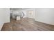 Open floor plan featuring wood-look tile, white kitchen, and staircase at 1479 Melodic Lark Dr, Las Vegas, NV 89138