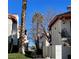 A sunlit exterior shot of townhouse-style homes with Spanish tile roofs and landscaping features at 1701 E Katie Ave # 42, Las Vegas, NV 89119