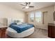 Bright bedroom with a round bed, tufted headboard, ceiling fan, and two large windows at 2149 Morro Vista Dr, Las Vegas, NV 89135