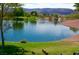 Picturesque pond view with a fountain, ducks, and green grass and trees, with a hill background at 2201 Tiger Links Dr, Henderson, NV 89012