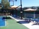 Bright outdoor tennis court with a blue and green surface, featuring shaded seating and well-maintained surroundings at 2201 Tiger Links Dr, Henderson, NV 89012