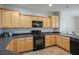 Well-lit kitchen with wood cabinets, tiled floor, and black appliances at 2629 Chateau Clermont St, Henderson, NV 89044