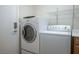 Convenient laundry room featuring a stacked washer and dryer unit and storage shelves at 2629 Chateau Clermont St, Henderson, NV 89044