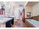 Well-appointed bathroom featuring dual sinks, a jetted tub, tiled accents, and closet access at 2967 Pinehurst Dr, Las Vegas, NV 89109