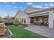 Landscaped backyard featuring a covered patio, manicured lawn, and a stacked stone water feature at 3018 Fall Solstice Ct, Las Vegas, NV 89138