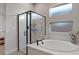 Bathroom features a tub, a corner shower, and frosted windows for increased privacy at 3018 Fall Solstice Ct, Las Vegas, NV 89138