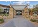 Inviting building entrance with stone columns, trellised walkway, and desert landscaping at 3018 Fall Solstice Ct, Las Vegas, NV 89138