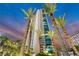 Stunning high rise exterior with palm trees in the foreground during an atmospheric dusk, perfect for luxury living at 322 Karen Ave # 2501, Las Vegas, NV 89109