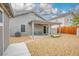 The backyard has a covered patio, seating, rock landscaping and a fenced perimeter at 3334 Flying Colt Ct, North Las Vegas, NV 89032