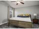 This bedroom offers neutral walls, a ceiling fan, carpeted floors and natural light from a window at 3334 Flying Colt Ct, North Las Vegas, NV 89032