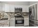 Close-up of kitchen featuring granite counters, stainless appliances, and white cabinetry at 3334 Flying Colt Ct, North Las Vegas, NV 89032